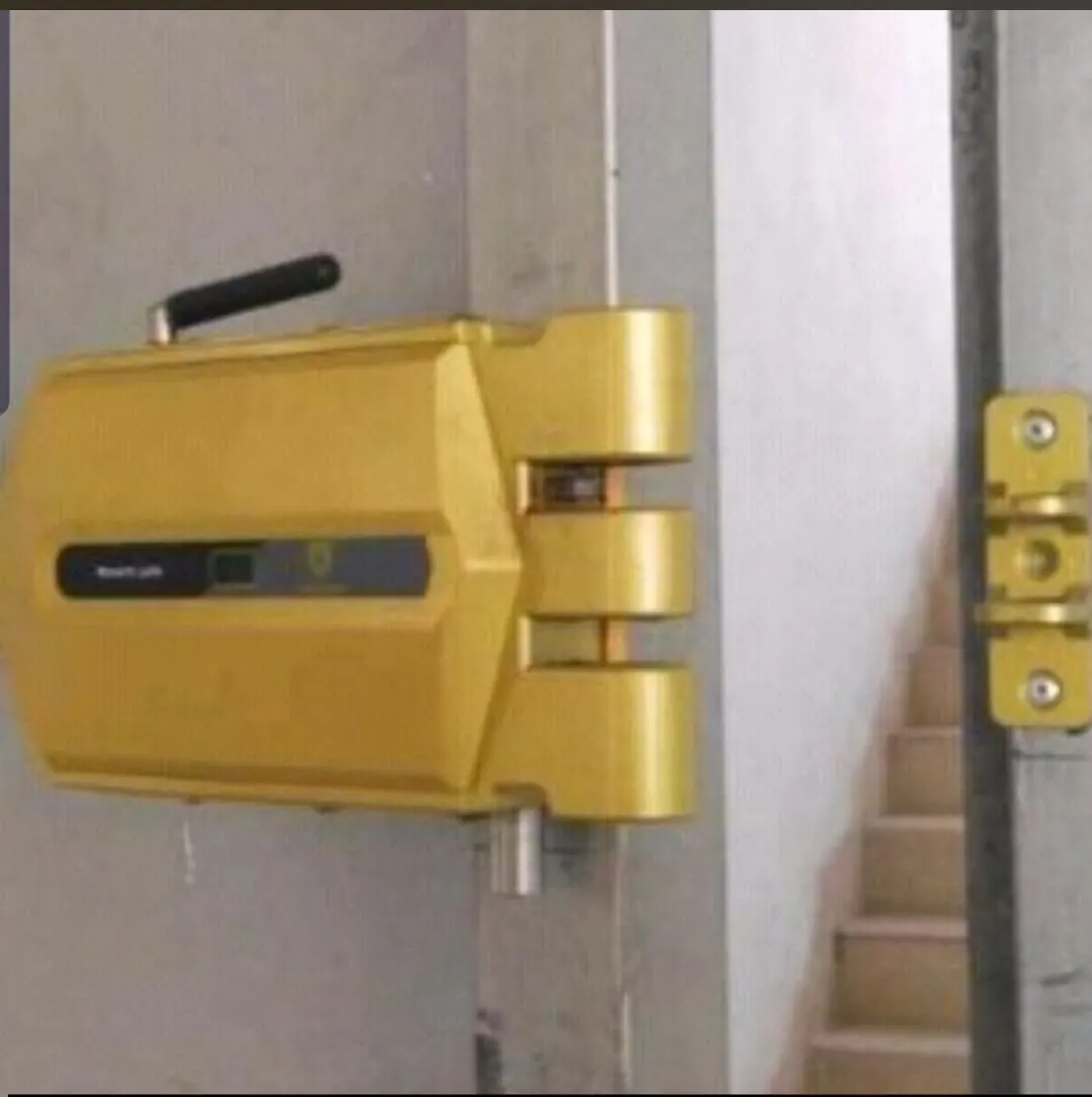 Cerradura invisible motorizada instalada en la cara interior de una puerta, con sus bulones de anclaje y el cerradero en el marco.