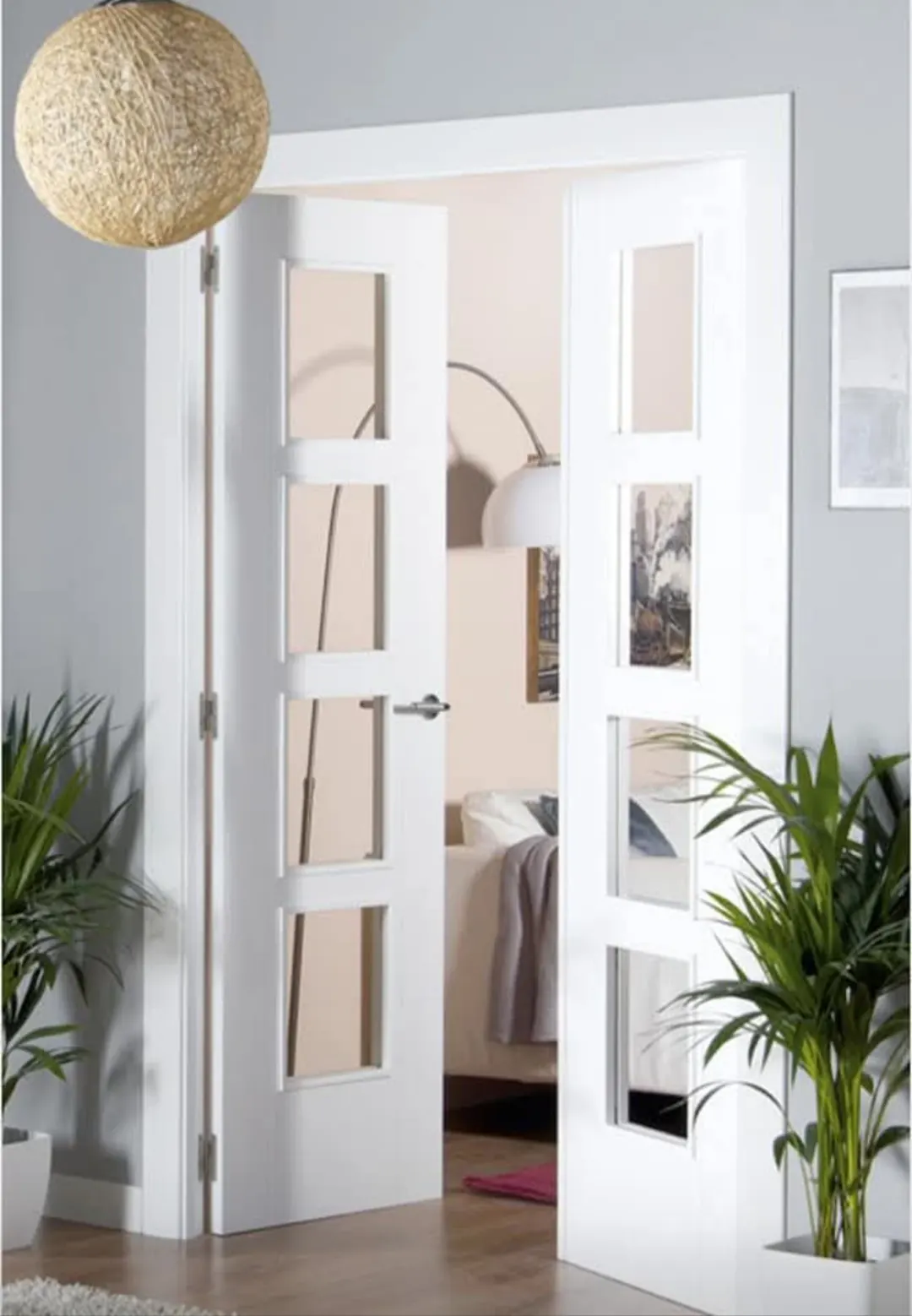 Puertas de interior lacadas en blanco con vidrios rectangulares, instaladas en una vivienda.